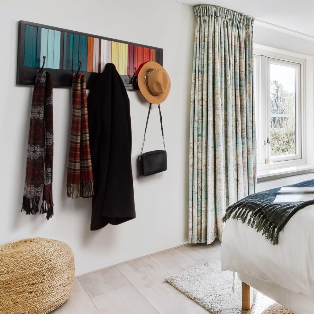 Imagen de estilo de vida para Amazon con el perchero de pared instalado en un dormitorio y abrigo, bufandas y sombrero colgados